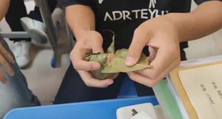 粽叶飘香处，文脉永传承——重庆市蜀都职业技术学校端午文化活动纪实 序言 在重庆市蜀都职业技术学校的校园里，当青绿的粽叶于掌心徐徐展开，糯米的软糯气息与千年的文明血脉悄然相逢。近期，一场以“粽”为纽带的文化之约在校园中温馨开启。这不仅仅是一场简单的活动，更是一次跨越时空的文化对话，引领着我们循着粽香，探寻历史长河中那些璀璨的文化星光。  汨罗江畔的千年回响 <图片> 透过蒸腾的热气，我们的思绪飘回战国时期。汨罗江畔，屈原投江的悲壮身影，永远镌刻在端午的记忆深处。那是一个动荡不安的时代，屈原心怀家国天下，却遭奸佞排挤，报国无门，最终以决绝的方式投身汨罗江，以死明志。  江畔的百姓们，怀着对屈原的敬仰与悲痛，纷纷掷粽入江，期望以此护住忠魂。自此，粽子从原本普通的食物，升华为一种精神图腾。它如同竹简承载着先贤的智慧，粽叶包裹着的，是中华民族“宁为玉碎，不为瓦全”的高尚气节。这种气节，在历史的长河中熠熠生辉，激励着一代又一代的中华儿女，在面对困难与挑战时，坚守正义，不屈不挠。  指尖缠绕的文化密码 <图片> 当我们亲手将糯米填入粽叶，再用五彩丝线仔细缠绕时，仿佛开启了一场跨越时空的对话。校园里，老一辈人坐在同学们身旁，手把手地传授包粽子的技巧。他们专注的神情、熟练的动作，无不透露出对传统文化的热爱与执着。  那些棱角分明的粽子，宛如一个个文化基因的生动载体。每一道褶皱、每一根丝线，都蕴含着深厚的文化内涵。它们承载着先辈们的生活智慧、审美情趣和价值观念。就像春燕筑巢般，每一代人都在为文明大厦添砖加瓦。我们在学习包粽子的过程中，不仅传承了一项传统技艺，更是在延续中华民族的文化血脉，让古老的文化在新时代焕发出新的生机。  教室里的温情续章 <图片> <图片> <图片> <图片> 教室里，粽香四溢，编织成了一幅独特的校园记忆画卷。或许有些同学会觉得粽子不如汉堡包时髦，但当我们静下心来，细细品味其中深意，就会发现粽子所蕴含的独特魅力。  粽叶的清香，需要文火慢炖才能充分释放，这恰似文化传承，需要耐心与时间的滋养。它不是一蹴而就的，而是在岁月的长河中，经过一代又一代人的传承与弘扬，才得以延续至今。那些藏在粽角里的蜜枣，不正象征着苦难中孕育的甘甜吗？中华民族在历史的长河中，历经无数艰难险阻，但正是这些苦难，铸就了我们坚韧不拔的民族精神，也孕育出了丰富多彩的文化瑰宝。  当我们咬开粽子的刹那，仿佛在咀嚼着先人的生活智慧。那些古老的传说、传统的习俗，都随着粽子的美味，融入了我们的血液，成为了我们生命的一部分。在教室里，同学们围坐在一起，分享着包粽子的喜悦，交流着对传统文化的感悟，这份温情与传承，将成为校园生活中最珍贵的回忆。  总结 千年粽香未散，今时文脉正长。在重庆市蜀都职业技术学校的校园里，这场以“粽”为媒的文化活动，让我们深刻感受到了中华文化的博大精深和源远流长。愿这抹穿越时空的青绿，成为你我生命里最温暖的文化胎记，时刻提醒着我们不忘初心，传承和弘扬中华民族的优秀传统文化。  当我们以粽叶为笺，以糯米为墨，写下的不仅是节日的仪式感，更是中华文明生生不息的注脚。让我们在粽香的陪伴下，继续前行，为中华文化的繁荣发展贡献自己的力量，让这千年文脉在新时代绽放出更加绚烂的光彩。